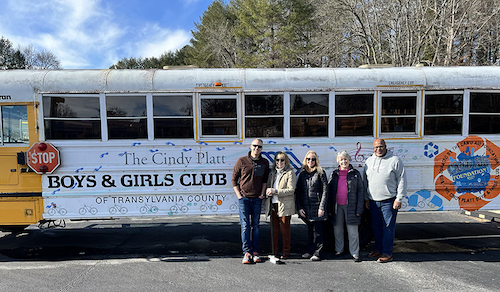 Brandon Smith, Vicki McGillin, Sara Stein Koch, and Ed Willis standing outside in front of Boys & Girls Club bus