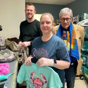 Cory Clasemann, Angie Whiteside, and John Gardner sorting clothing at Sharing House